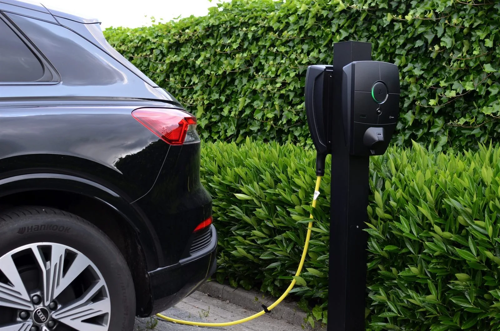 Elektrische auto aan een laadpaal bij een woning
