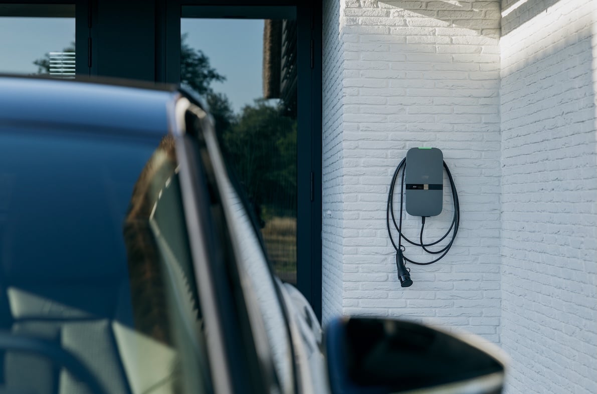 Peblar laadpaal met vaste kabel op de muur naast een auto