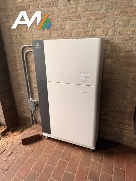 AlphaESS SMILE thuisbatterij tegen een bakstenen muur, met de kabels in een buis