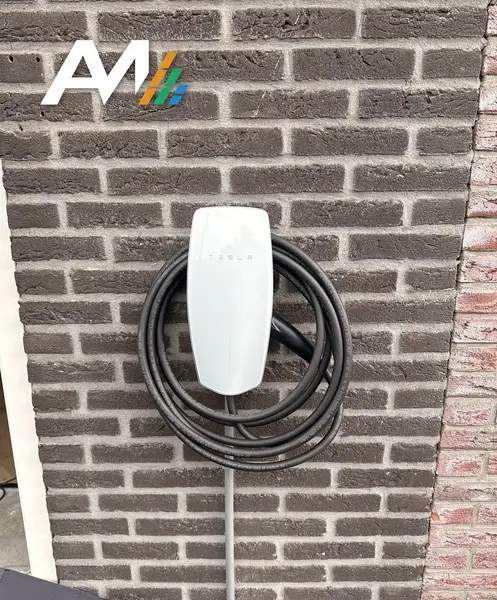 Tesla Wall Connector met opgerolde kabel aan een donkere bakstenen muur