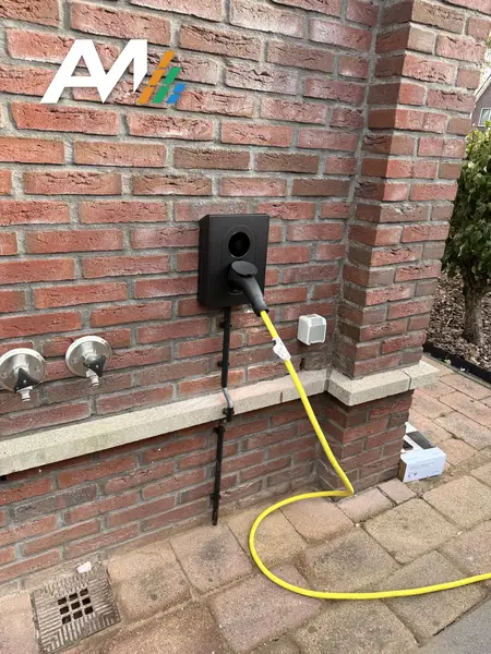Zaptec Go-laadpaal aan een bakstenen gevel met een aangesloten laadkabel