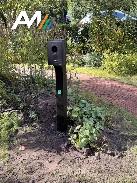 Zaptec Go op een paal in de border naast het tuinpad