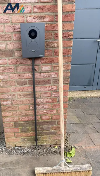 Zaptec Go op een gemetselde muur naast de garagedeur