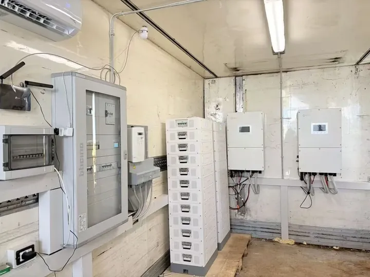 Dyness STACK100 in een technische ruimte met omvormers en verdeelkast