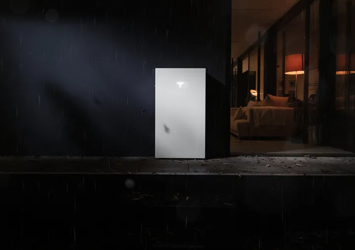 Tesla Powerwall 3P in de regen bij nacht