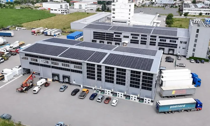 Luchtfoto van een koel- en logistiekpark met zonnepanelen en batterijkasten