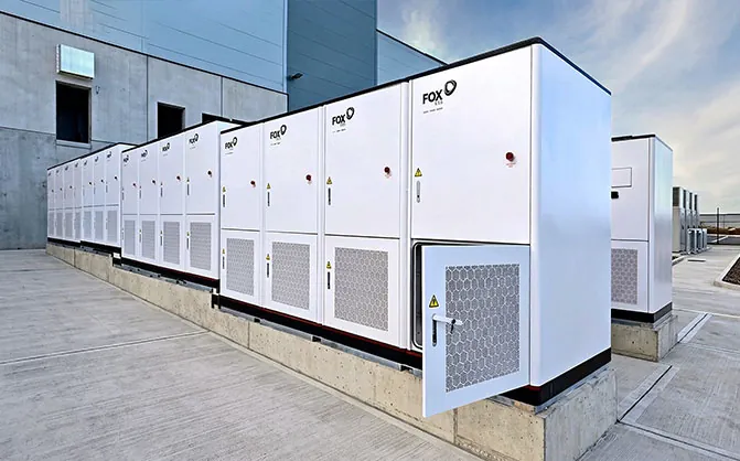 Lange rij FoxESS G-MAX Plus-kasten langs een industriehal
