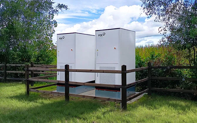 Twee FoxESS G-MAX Plus-kasten achter een houten hek op een grindvlak