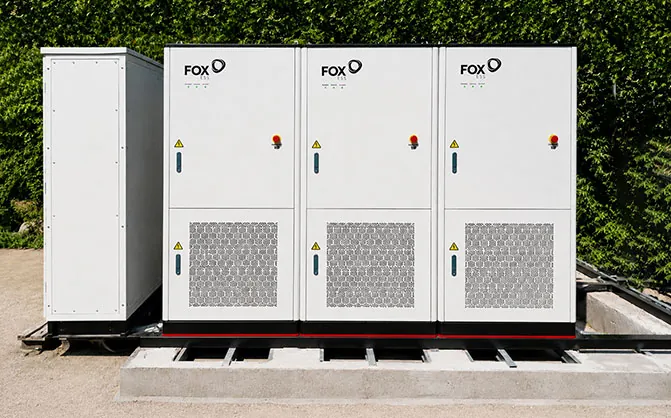 Drie FoxESS-kasten naast een technische kast op een betonfundatie
