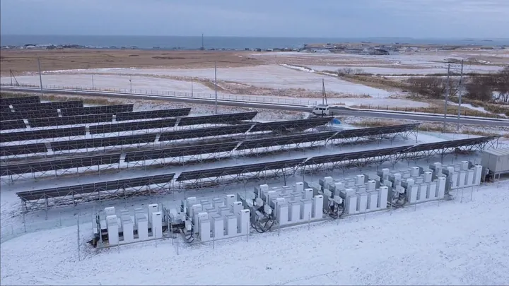 Luchtfoto van een besneeuwd zonnepark met SigenStack-opslag